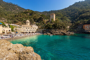 Beach with tourists in San Fruttuoso bay with the ancient Abbey (San Fruttuoso di Capodimonte),...