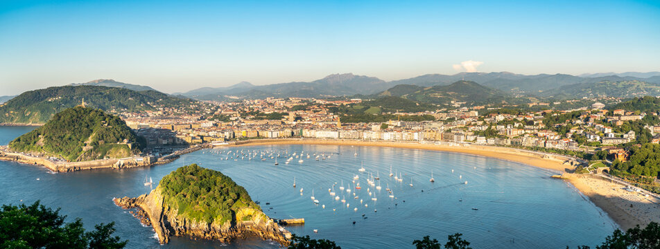 High angle view of San Sebastian - Donostia city at sunset. Situated in north of Spain, Basque Country. Famous travel destination. View of La Concha Bay, Santa Clara Island. Warm sunset colours  