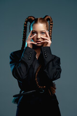 Portrait, girl with braids, beautiful glamorous woman holds her fingers near her face, neon light shines on her