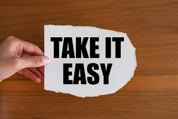 Take it easy. Woman hand holds a piece of paper with a note, take it easy. Motto, positive emotion,...
