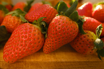 appetizing ripe red fresh strawberries, Fragaria, on wooden board, illuminated rays sun, fresh vitamin juicy fruit, concept rich harvest gardening, vegetarian, vitamin, wholesome food, healthy eating