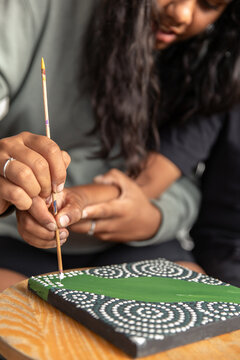 Aboriginal girl and boy dot painting together