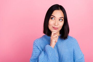 Photo of gorgeous thoughtful woman straight hairdo dressed knit pullover look empty space hand on chin isolated on pink color background