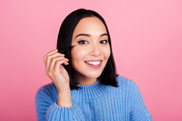 Portrait of cute lovely person toothy smile hand hold apply eyeliner isolated on pink color background - obrazy, fototapety, plakaty