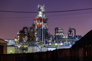 Fototapeta na wymiar 廃鉄置き場の先に見える工場のプラント、工場夜景