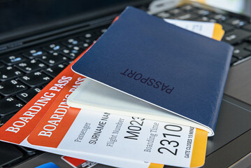 Two boarding pass with a passport on a laptop keyboard. - obrazy, fototapety, plakaty