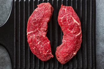 Fresh meat. Raw beef steaks on a stylish blackboard. Flat top view.