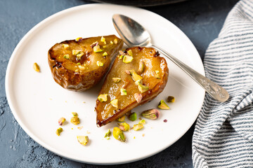 Baked and caramelized pears with honey and chopped pistachio