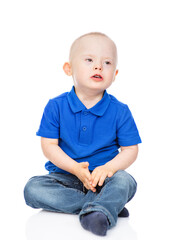 Young boy with Downs syndrom wearing casual clothes  sits and looks away. Isolated on white background
