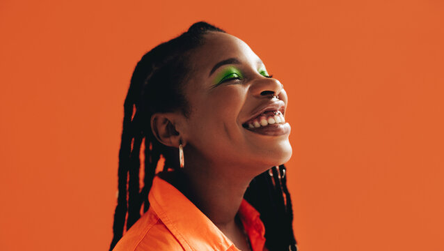 Happy african woman with makeup smiling with her eyes closed
