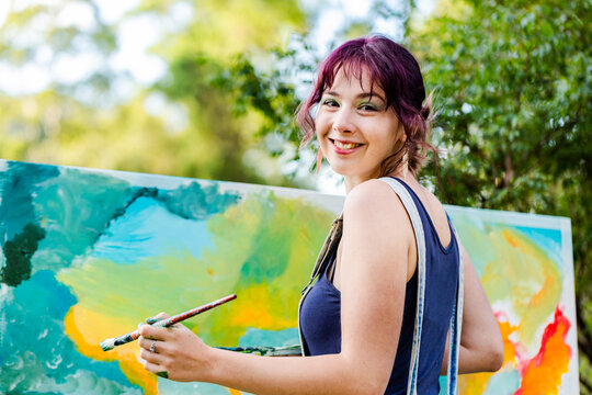 portrait of young australian artist beside painting outdoors