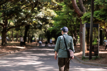 公園をひとりで歩く男性高齢者