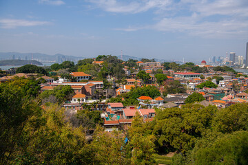 Fototapeta na wymiar Close up on the roofs of the old historical buildings of Gulangyu Island, Xiamen City, Fujian Province, China. Blue sky with copy space for text, wallpaper