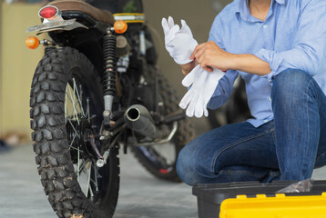 Fototapeta na wymiar Mechanic working in motorcycle repair shop, wearing protective gloves. Bike Maintenance Concept.