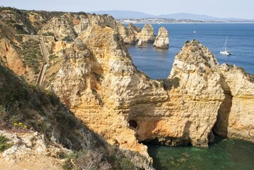 Fototapeta na wymiar Lagos, Portugal - April 10, 2023: Wonderful landscapes in Portugal. Scenic and coloured view of Ponta da Piedade in the Algarve region. Yellow rocky skerries. Sunny spring day. Selective focus