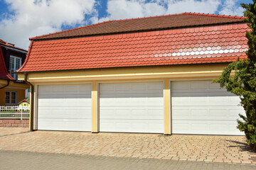Frei stehende Dreifach-Garage mit Automatiktoren und ziegelgedecktes Satteldach