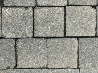 Background texture of cobblestone or paving slabs, pavement. The pavement is laid with gray stones in Bandung, and can be used for texture design and background with copy space.