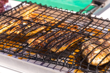Close-up of baked fish on a grill at a fish festival on a sunny day