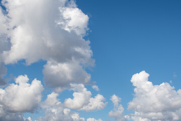 Fluffy cumulus clouds under a blue sky background