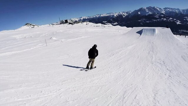 Downhill slopestyle skiing over obstacles with various tricks, scenic Swiss Alps