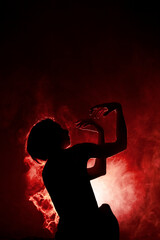 Silhouette modern ballet dancer. Ballerina posing against black with smoke in the background