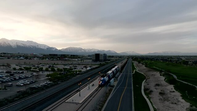 Commuter train at the station of a city suburb - aerial flyover