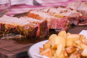 Roast pork loin with mustard and honey on wooden cutting board close up