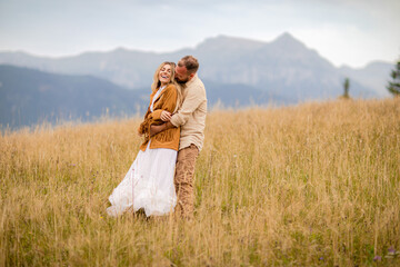 .Amidst nature, the couple embraces in a tender embrace, gazing at the splendid landscape, with...