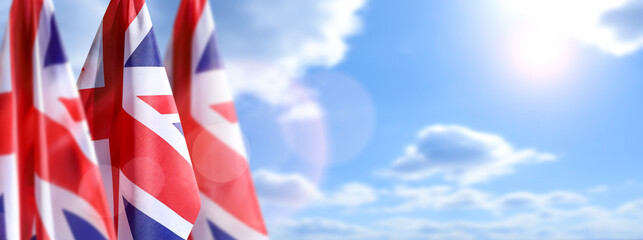 UK flags on the sky background. Great Britain holiday concept.