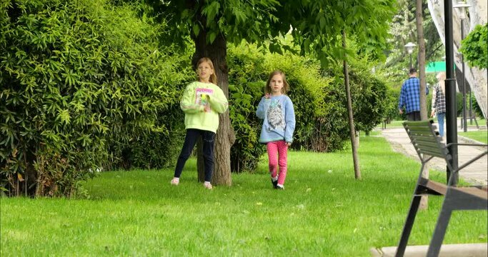 two children with blond hair have fun and play on the green carpet