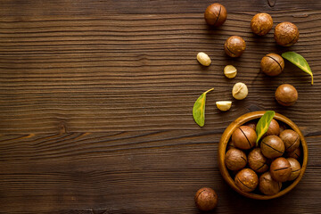 Flat lay of macadamia nuts in bowl, top view. Healthy food background