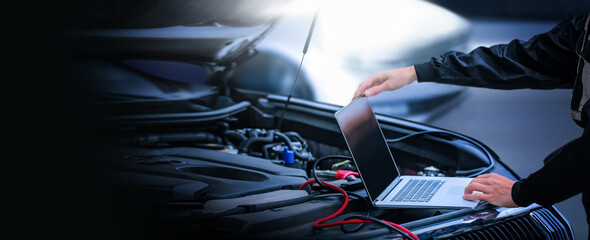 Car diagnostic service close up  Mechanic looking into computer. Modern mechanic work in garage. Auto mechanic using computer software for diagnostics engine working and repairing car in a garage.