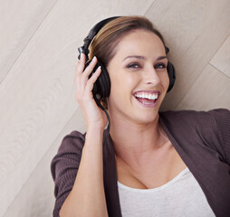 Naklejka premium Music is my escape. Portrait of a beautiful woman listening to music over her headphones.
