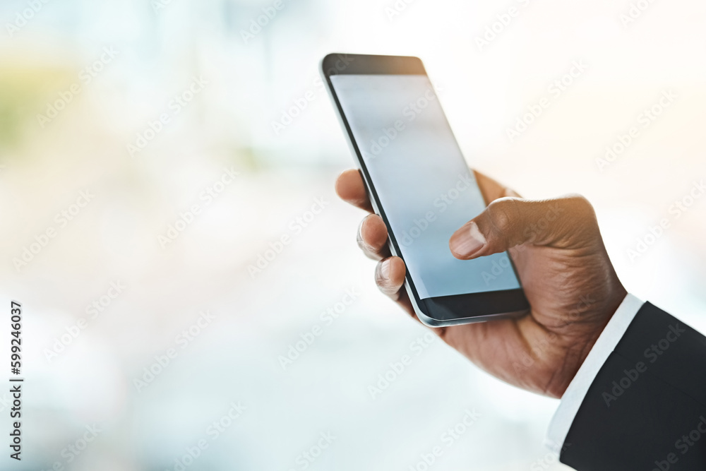 Poster responding to his texts. closeup shot of an unrecognizable businessman using a cellphone in an offic