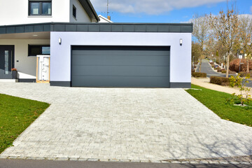 Moderne Beton-Garage mit Automatik-Tor in der Hauszufahrt