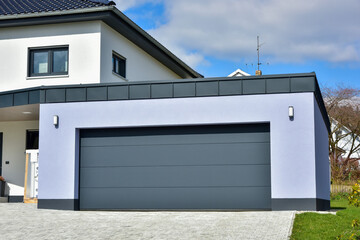 Moderne Beton-Garage mit Automatik-Tor in der Hauszufahrt