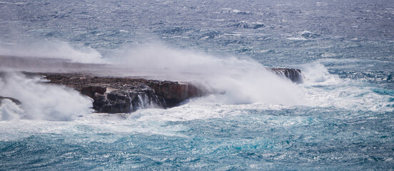 Seascape with big waves in the sea. Banner with ocean landscape during a storm, big waves hitting the rocks