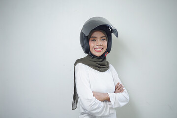 Smiling young Asian muslim woman using motorcycle helmet isolated on white background