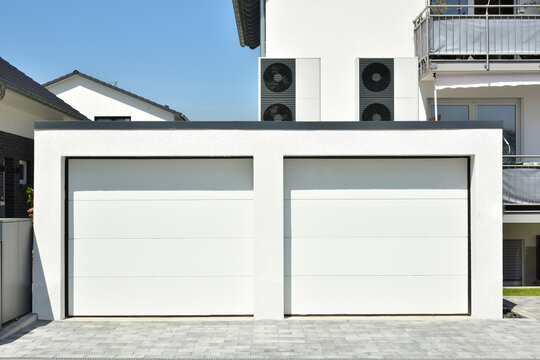 Luftw&auml;rmepumpe, Klimaanlage f&uuml;r Heizung und Warmwasser aufgebaut auf der Doppelgarage eines neu gebauten Wohnhauses