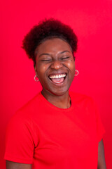 Fototapeta na wymiar Young african american woman isolated on a red background smiling and laughing, studio shoot