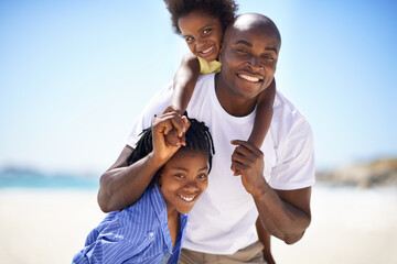 Their father is their rock. A father spending some time with his children on the beach.