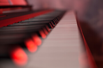 selective focus piano, close up, copy space, red studio light