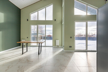 empty space of a house without furniture with large windows to the floor on two floors