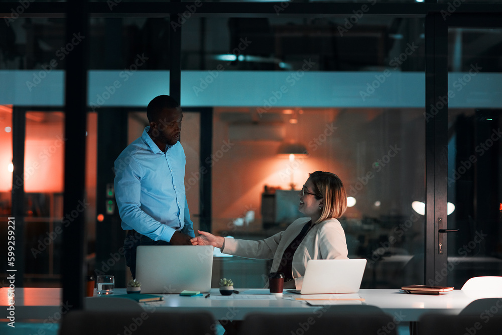 Poster Nocturnal business negotiations. a businessman and businesswoman shaking hands during a late night at work.