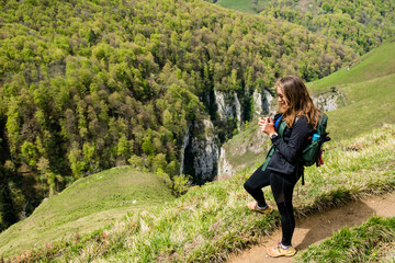 Young woman in sportswear doing a breack during a hike near Holzarté in the French Basque Country
