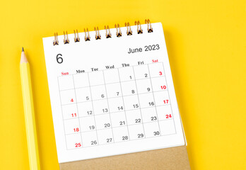 The June 2023 Monthly desk calendar for 2023 with pencil on yellow background.