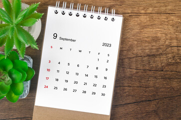 The September 2023 desk calendar for 2023 on wooden background.