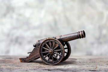 Ancient cannon on steel wheels with wall background retro style.