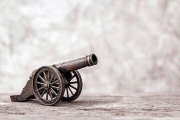 Ancient cannon on steel wheels with wall background retro style and copy space. - obrazy, fototapety, plakaty