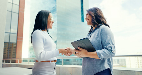 Business, women on rooftop and handshake with tablet, collaboration and partnership for new...